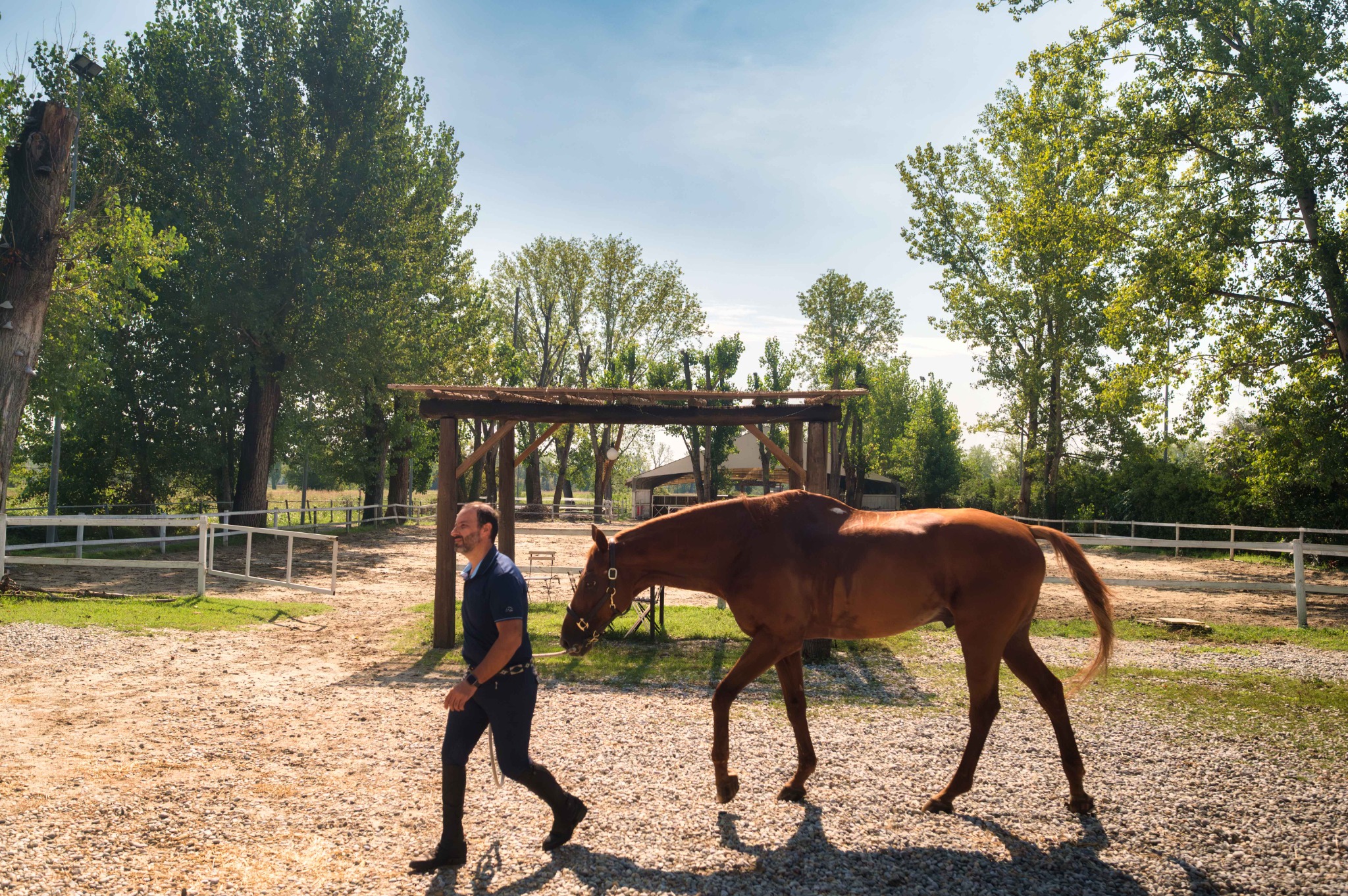 Un uomo conduce un cavallo a mano lungo il percorso davanti al campo esterno del Remolino.