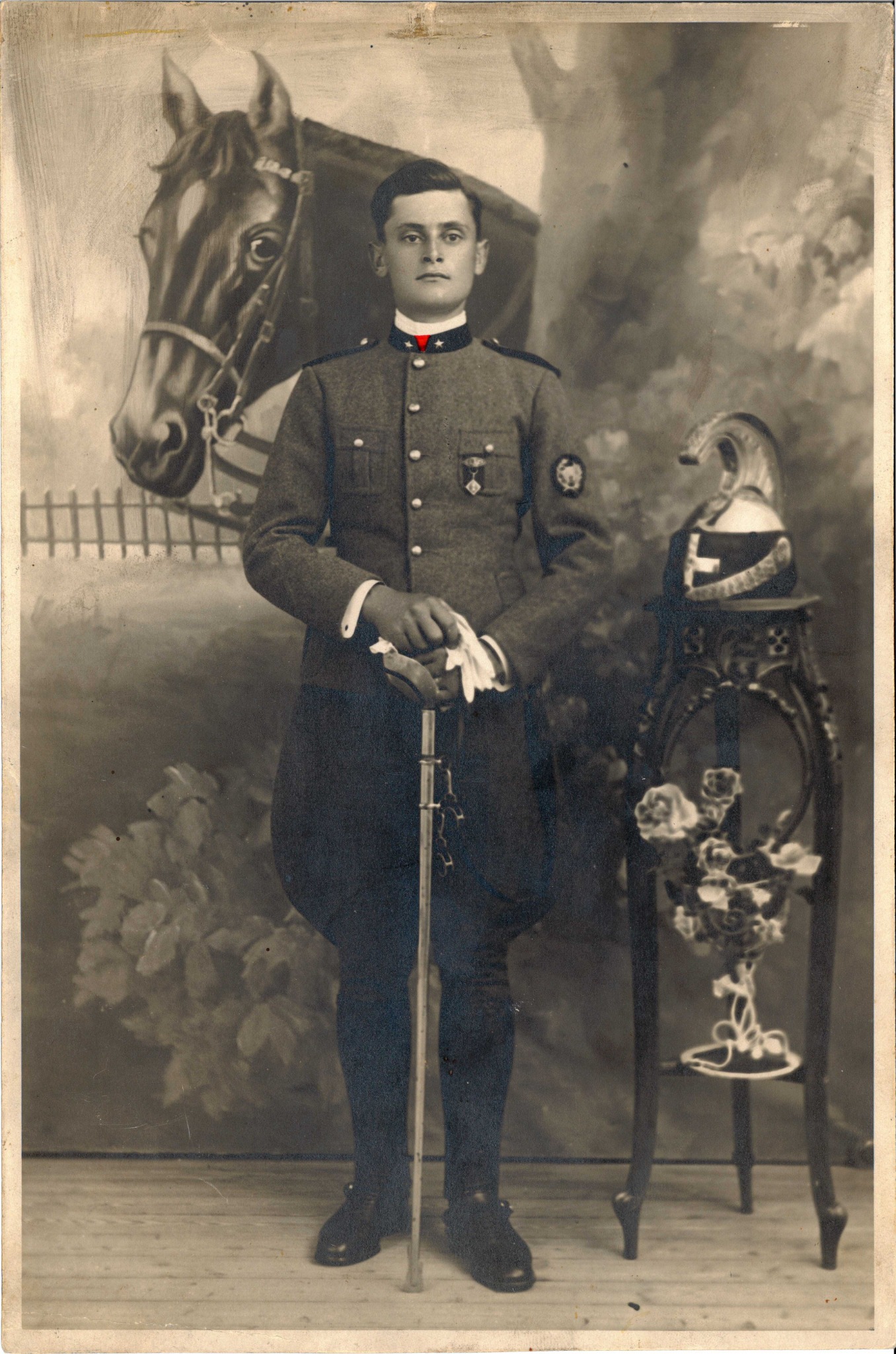 Ritratto d’epoca di nonno Silvio in uniforme, davanti a un fondale con un cavallo.