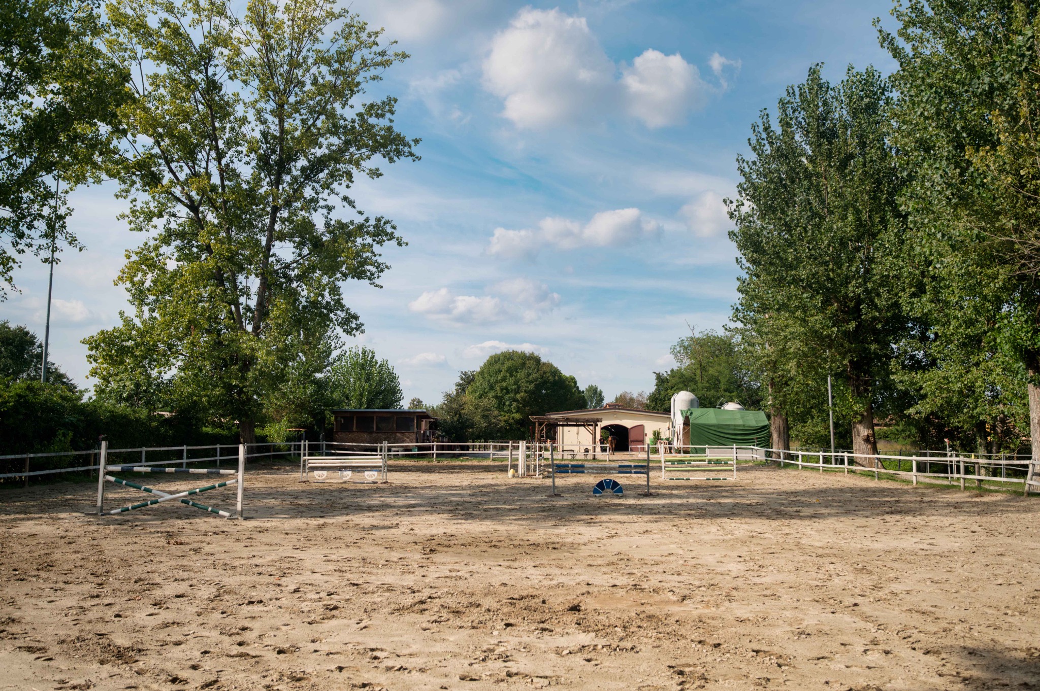 Panoramica del campo esterno con ostacoli, club house sulla sinistra e scuderia sullo sfondo.