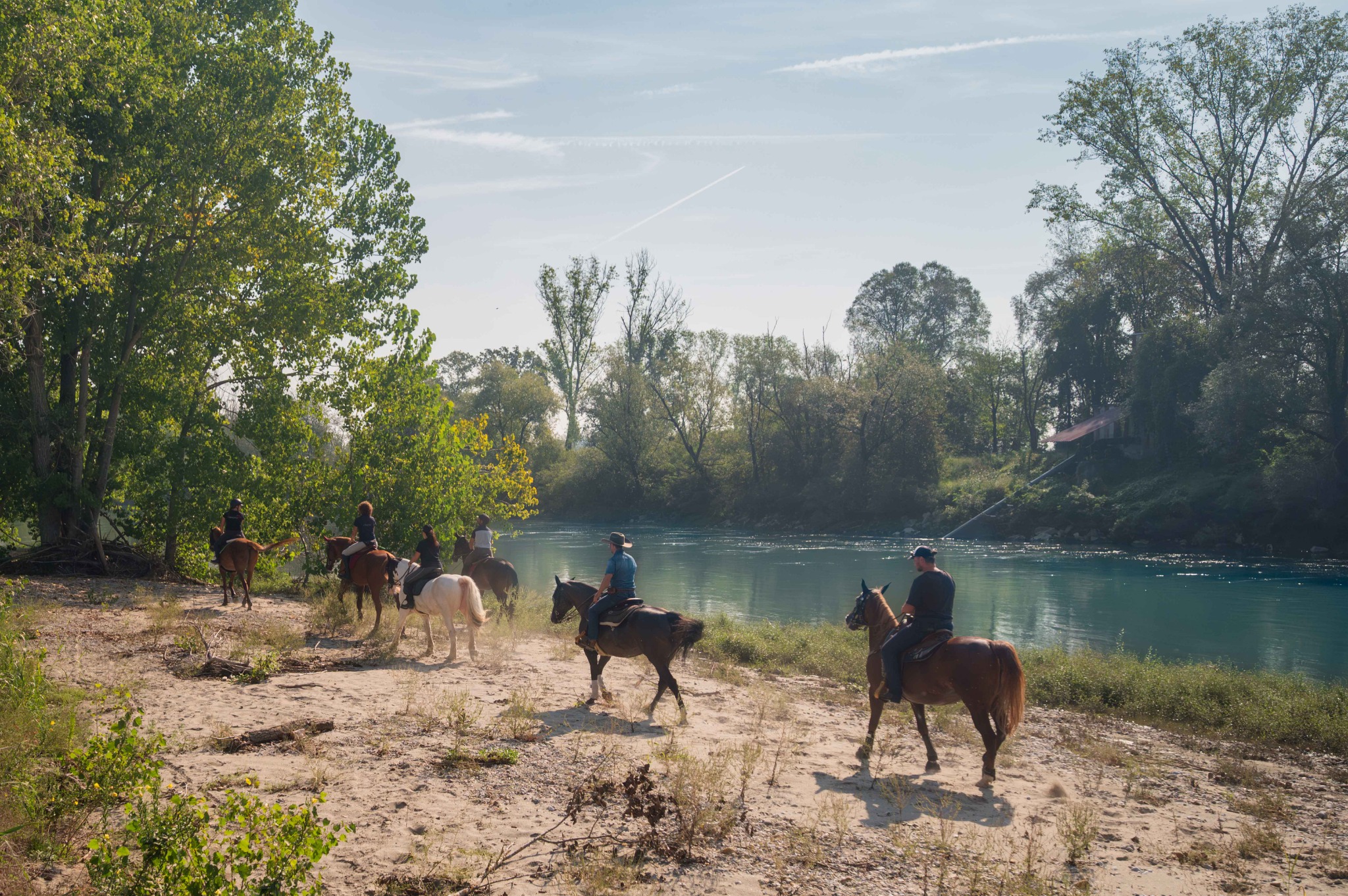 Cavalieri lungo la riva del fiume Adda durante un’uscita di gruppo.